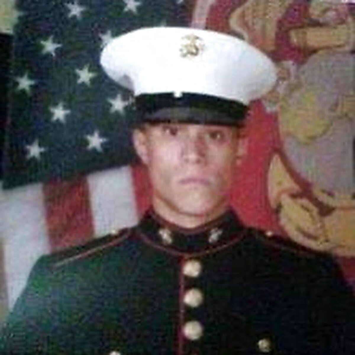 Markus in dress blues beside an American flag