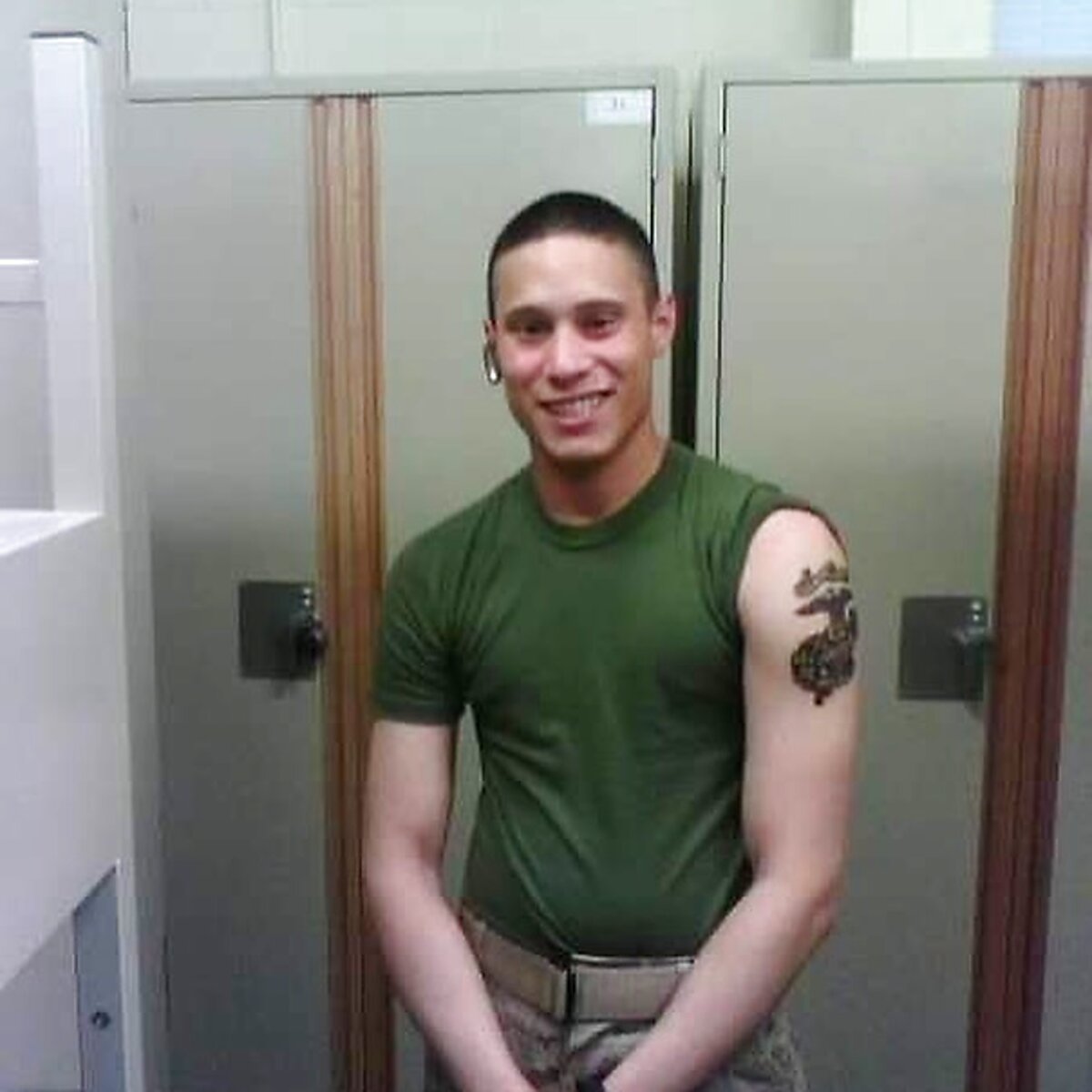 Markus in a green USMC tee with an eagle-globe-and-anchor tattoo, smiling